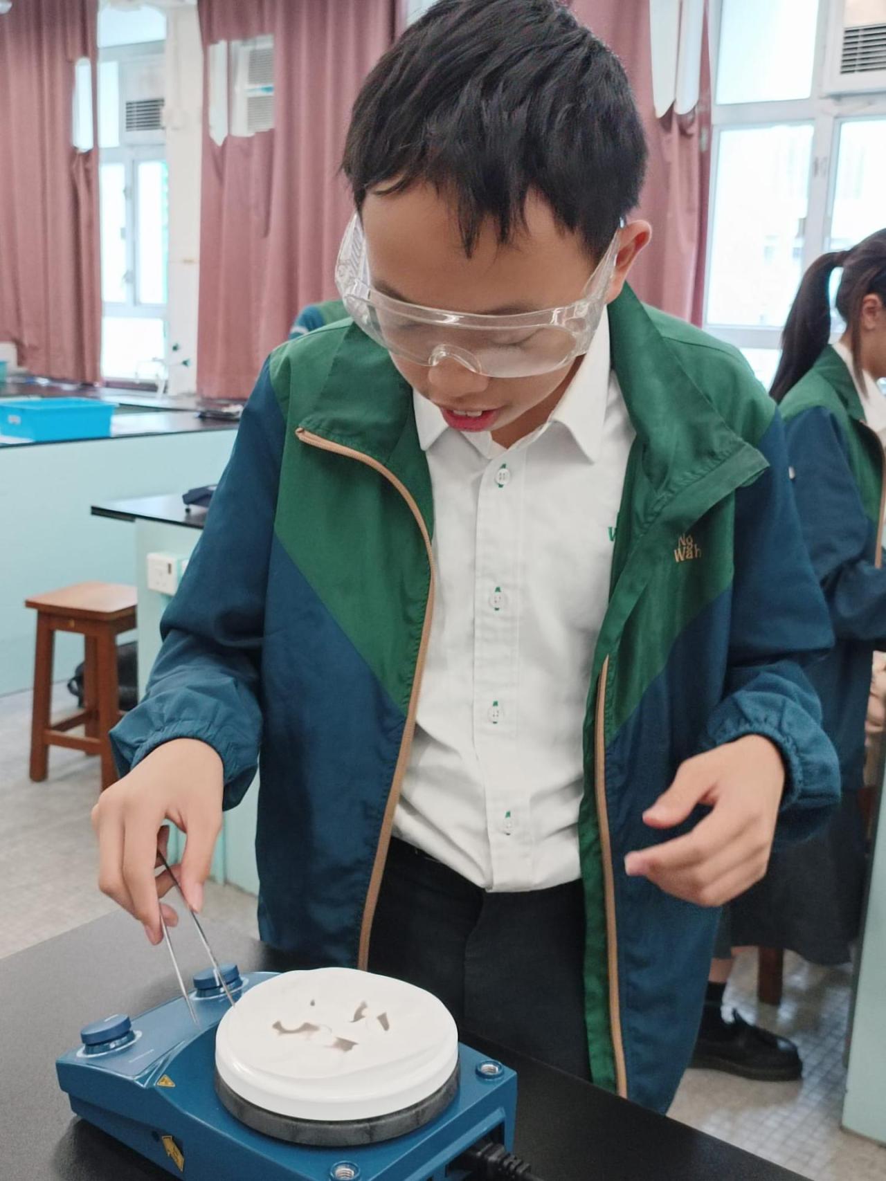 周四聯課活動(科學探索小組)(2025-26) 學生們用檸檬汁在紙上寫字，風乾後無痕，再以電熱板輕烤，字跡便因焦化反應而浮現，如解密般驚喜又有趣。